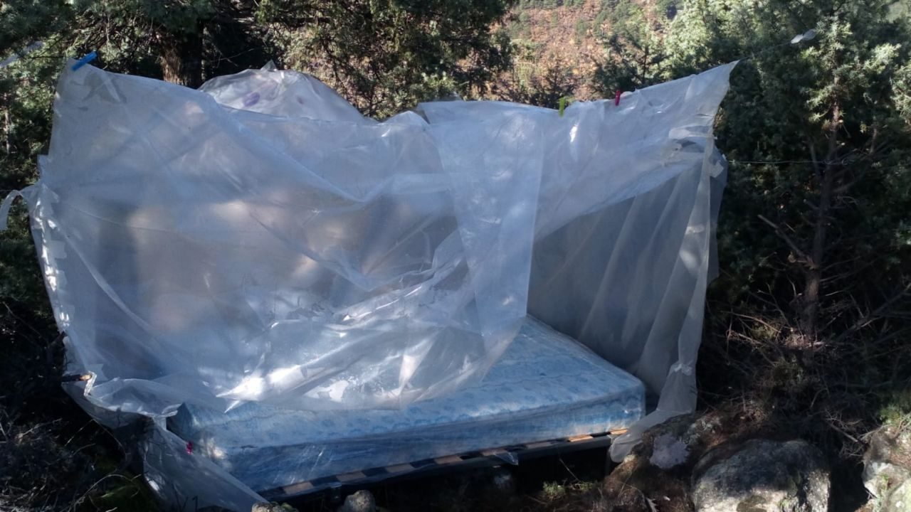 Un refugio de plástico sobre un colchón en la sierra